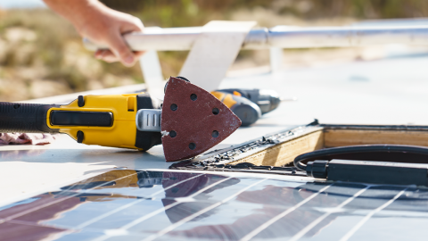 Ein Monteur installiert Solarmodule auf einem Wohnmobil
