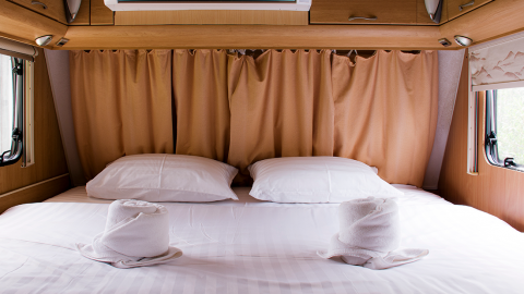 Innenaufnahme eines Längsbettes im Wohnmobil