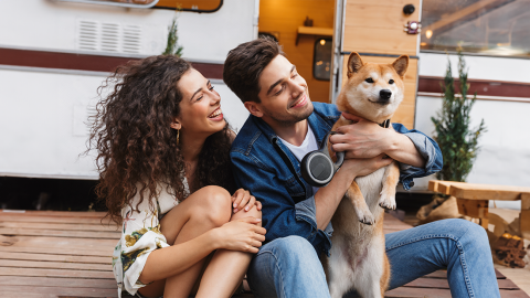 Camper mit Hund vor dem Wohnmobil